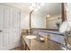 Bathroom with granite countertop, large mirror and tiled floors at 7609 Heritage Crossing Way # 201, Reunion, FL 34747