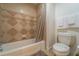 Clean bathroom with tub and shower, tile surround, and neutral tones at 7609 Heritage Crossing Way # 201, Reunion, FL 34747