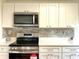 Modern kitchen featuring stainless steel appliances, tile backsplash, and ample counter space at 7839 Murcott Cir, Orlando, FL 32835