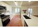 Bright kitchen with stainless steel appliances, white cabinets, and brick-look floors at 7839 Murcott Cir, Orlando, FL 32835