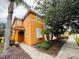 Two-story orange house with white shutters and a walkway at 840 Las Fuentes Dr, Kissimmee, FL 34746