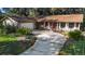 Ranch style home with red door and landscaped yard at 847 Lake Charm Dr, Oviedo, FL 32765