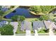 Aerial view of homes surrounding a tranquil pond, each with private pools and lush landscaping at 890 Moonluster Dr, Casselberry, FL 32707