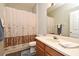 Hall bath with single sink vanity, mirror, toilet, and shower with decorative shower curtain at 890 Moonluster Dr, Casselberry, FL 32707