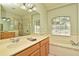 Bright bathroom features a soaking tub with tile surround, double vanities, and glass enclosed shower stall at 890 Moonluster Dr, Casselberry, FL 32707
