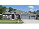 Charming single-story home with a gray exterior, well-maintained landscaping, and a three-car garage at 890 Moonluster Dr, Casselberry, FL 32707