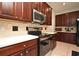Contemporary kitchen with stainless steel appliances, dark wood cabinets, and white countertops at 890 Moonluster Dr, Casselberry, FL 32707
