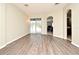 Bright living room featuring wood-look flooring, arched doorways, and sliding glass doors to the backyard at 890 Moonluster Dr, Casselberry, FL 32707