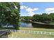 Scenic pond view from a backyard with a white fence, providing a private and serene atmosphere at 890 Moonluster Dr, Casselberry, FL 32707