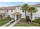 Inviting townhome featuring stucco walls, a tile roof, well-manicured lawn and mature palm trees at 9043 Dogleg Dr, Davenport, FL 33896