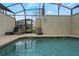 Enclosed private pool area with lounge chairs and a screened enclosure at 9043 Dogleg Dr, Davenport, FL 33896