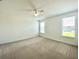 Spacious bedroom with carpeted floors, ceiling fan and two windows at 10432 Austrina Oak Loop, Winter Garden, FL 34787