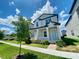 Two-story house with light gray siding, blue door, and a landscaped front yard at 10432 Austrina Oak Loop, Winter Garden, FL 34787