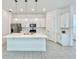 Modern kitchen with white cabinets, quartz countertops, and stainless steel appliances at 10432 Austrina Oak Loop, Winter Garden, FL 34787