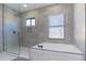 Spa-like bathroom featuring a soaking tub and a glass-enclosed shower at 10483 Kristen Park Dr, Orlando, FL 32832