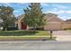 Two-story house with tan exterior, red door, and brick driveway at 13633 Glynshel Dr, Winter Garden, FL 34787