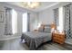 Comfortable bedroom with a wooden bed frame, gray bedding, and natural light from two windows at 219 Plumoso Loop, Davenport, FL 33897