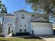 Charming two-story home with landscaped yard, white trim, and an attached two-car garage at 219 Plumoso Loop, Davenport, FL 33897