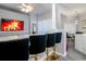 Bright kitchen features white cabinets, stainless steel appliances, an island, and bar stools at 219 Plumoso Loop, Davenport, FL 33897