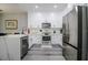 Well-lit kitchen with white cabinetry, stainless steel appliances, and modern countertops at 219 Plumoso Loop, Davenport, FL 33897