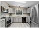 Bright kitchen features stainless steel appliances, ample grey cabinets and granite countertops at 228 Westwood Dr, Leesburg, FL 34748