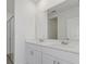 Bathroom with double vanity, white cabinets, and large mirror at 248 Links Terrace Blvd, Daytona Beach, FL 32124