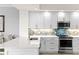 Modern kitchen with white cabinets, stylish backsplash and stainless steel appliances at 263 Minorca Beach Way # 301, New Smyrna Beach, FL 32169