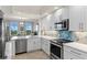 Modern kitchen with white cabinets and stainless steel appliances at 263 Minorca Beach Way # 301, New Smyrna Beach, FL 32169