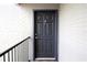 Condo building entry with dark gray door and brick wall at 3700 Idlebrook Cir # 208, Casselberry, FL 32707