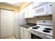 White kitchen cabinets, dark countertops, and appliances at 3700 Idlebrook Cir # 208, Casselberry, FL 32707