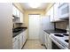 Galley kitchen with white cabinets, dark countertop, and appliances at 3700 Idlebrook Cir # 208, Casselberry, FL 32707