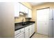 White kitchen with dark countertops and stainless steel sink at 3700 Idlebrook Cir # 208, Casselberry, FL 32707