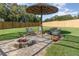 Relaxing fire pit area with seating under a thatched umbrella at 5210 Sailwind Cir, Orlando, FL 32810