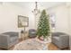 Cozy living room with two comfy armchairs, a Christmas tree, and a neutral color scheme at 5210 Sailwind Cir, Orlando, FL 32810