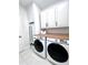 Bright laundry room with washer, dryer, and wood countertop at 526 First Cape Coral Dr, Winter Garden, FL 34787