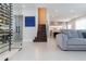 Open living area features a gray sofa, modern staircase, and a glass-enclosed wine cellar at 526 First Cape Coral Dr, Winter Garden, FL 34787