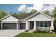 Two-story house with gray siding, dark gray garage doors, and landscaping at 5278 Bowspirit Way, St Cloud, FL 34769