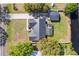 An aerial view shows the metal roof, screened patio and the house is nestled by a pond at 6121 Bass Hwy, St Cloud, FL 34771