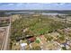 A distant aerial view shows the neighborhood, showcasing a metal roof home by the water and its community setting at 6121 Bass Hwy, St Cloud, FL 34771