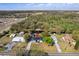 An aerial view shows a home surrounded by lush greenery with a pond in the backyard and a metal roof on the home at 6121 Bass Hwy, St Cloud, FL 34771