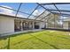 Expansive backyard includes a covered patio, screened lanai, and lush green lawn at 6121 Bass Hwy, St Cloud, FL 34771