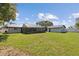 Large grassy backyard with a screened-in lanai and separate outbuilding at 6121 Bass Hwy, St Cloud, FL 34771