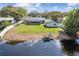 Aerial view showcasing a well-kept backyard with a metal roof, screened patio, and a private dock on a tranquil pond at 6121 Bass Hwy, St Cloud, FL 34771