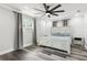 Cozy bedroom boasts a whitewashed bed frame, modern ceiling fan, and grey curtains for a relaxing ambiance at 6121 Bass Hwy, St Cloud, FL 34771