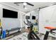 Well-equipped exercise room with a peloton bike, free weights, and a wall-mounted TV at 6121 Bass Hwy, St Cloud, FL 34771