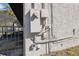 Exterior wall featuring electrical box, meter, and conduit, positioned near a black fence and screened patio in the backyard at 6121 Bass Hwy, St Cloud, FL 34771