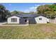 Charming single-story home features a dark metal roof, a modern black gate, and well-maintained front yard landscaping at 6121 Bass Hwy, St Cloud, FL 34771