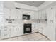 Functional kitchen featuring white cabinets, black appliances, and tiled backsplash and floor at 6121 Bass Hwy, St Cloud, FL 34771