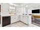 Well-lit kitchen with white cabinets, a sink, and an adjacent seating area and pool table at 6121 Bass Hwy, St Cloud, FL 34771