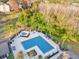 Aerial view of a pool and spa surrounded by green trees, lounge chairs, and a fence at 629 Dory Ln # 108, Altamonte Springs, FL 32714